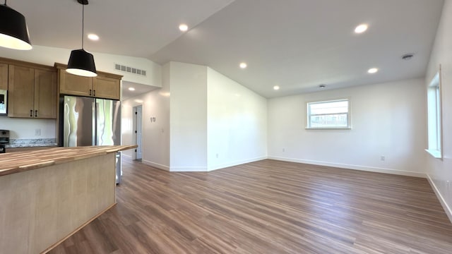 703 2nd St, Henning, MN 56551 - kitchen featuring butcher block countertops, baseboards, wood finished floors, vaulted ceiling, and pendant lighting