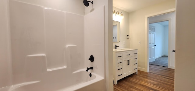 703 2nd St, Henning, MN 56551 - full bathroom featuring wood finished floors, shower / washtub combination, vanity, and baseboards