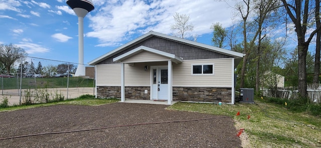 703 2nd St, Henning, MN 56551 - view of front of property with stone siding, cooling unit, and fence