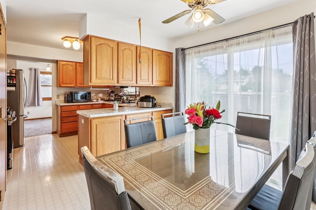 6012 Beard Ave N, Brooklyn Center, MN 55429 - kitchen with a ceiling fan, light countertops, freestanding refrigerator, baseboards, and a sink