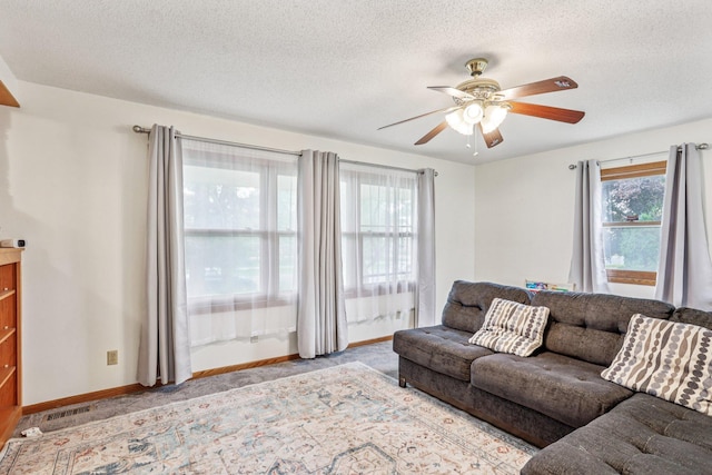 6012 Beard Ave N, Brooklyn Center, MN 55429 - carpeted living area featuring ceiling fan, a textured ceiling, and baseboards