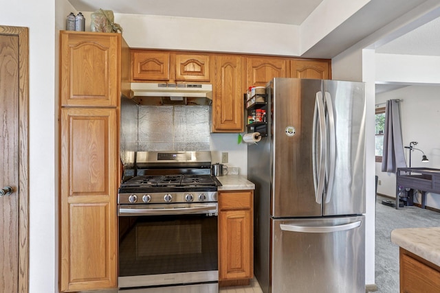 6012 Beard Ave N, Brooklyn Center, MN 55429 - kitchen with appliances with stainless steel finishes, under cabinet range hood, brown cabinetry, and light countertops