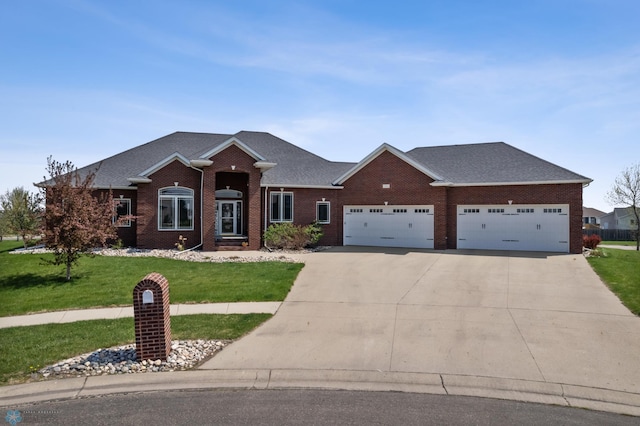 3914 21st Ave S, Moorhead, MN 56560 - view of front of home with driveway, a garage, brick siding, a front lawn, and roof with shingles