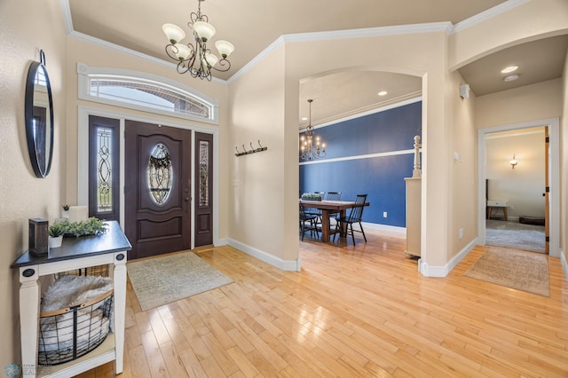 3914 21st Ave S, Moorhead, MN 56560 - foyer entrance with a chandelier, arched walkways, baseboards, light wood-style flooring, and crown molding