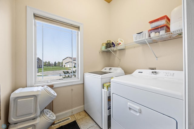 3914 21st Ave S, Moorhead, MN 56560 - laundry area with washer and clothes dryer, baseboards, and light tile patterned flooring