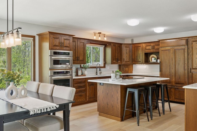 kitchen featuring light wood finished floors, light countertops, and a kitchen island