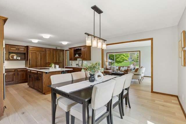 dining area featuring light wood finished floors and baseboards