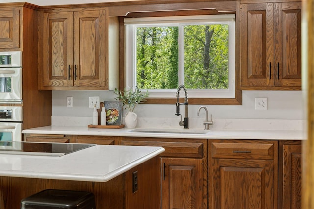 kitchen with a sink, brown cabinets, and light countertops