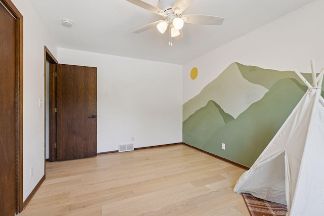 spare room featuring wood finished floors, a ceiling fan, and baseboards