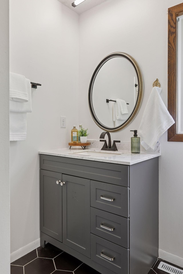 bathroom with tile patterned flooring, vanity, and baseboards