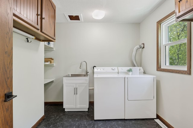 laundry room featuring washing machine and clothes dryer, cabinet space, and baseboards