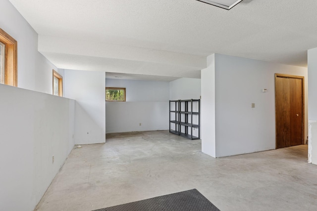 empty room with concrete floors and a textured ceiling