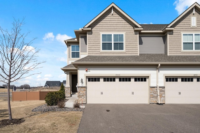 19000 72nd Pl N, Maple Grove, MN 55311 - view of front facade featuring a garage, asphalt driveway, and stone siding