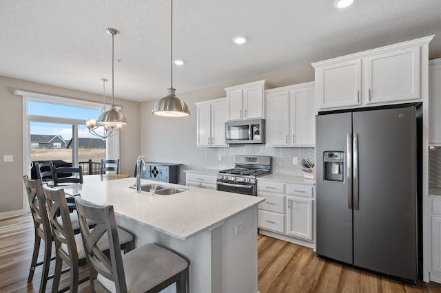 19000 72nd Pl N, Maple Grove, MN 55311 - kitchen featuring stainless steel appliances, a sink, light wood-style flooring, a chandelier, and backsplash