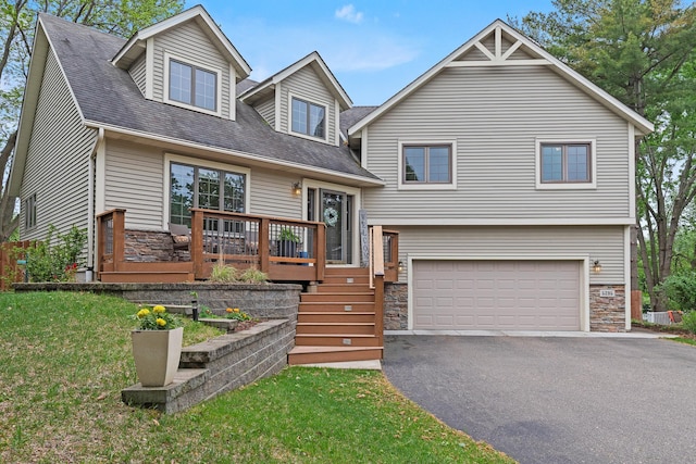 5295 Pleasant Ct W, White Bear Twp, MN 55110 - tri-level home with stone siding, an attached garage, asphalt driveway, a front lawn, and a wooden deck