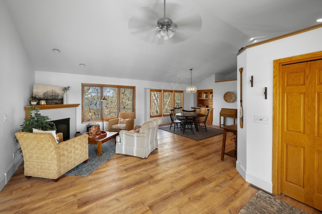 29825 Minerva Cir, Swiss Twp, WI 54830 - living room with vaulted ceiling, ceiling fan, light wood-style floors, a glass covered fireplace, and baseboards