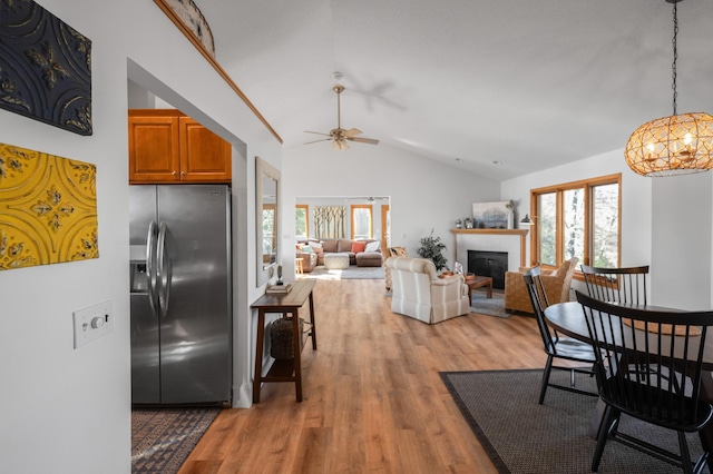 29825 Minerva Cir, Swiss Twp, WI 54830 - dining space with lofted ceiling, plenty of natural light, light wood-style floors, a glass covered fireplace, and ceiling fan