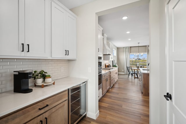 kitchen with wine cooler, wood finished floors, light countertops, white cabinets, and recessed lighting