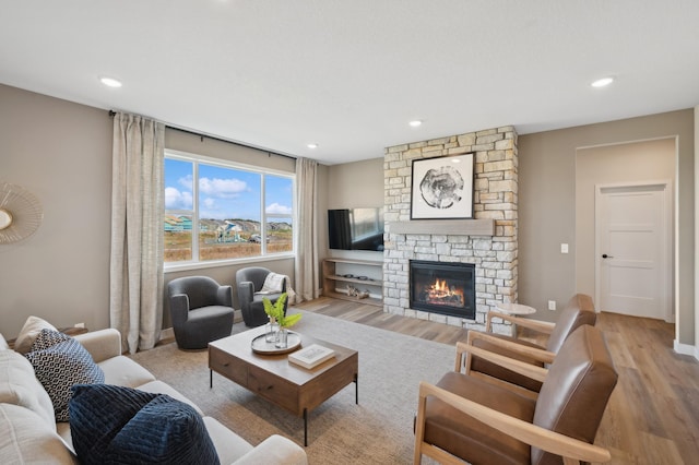 living area with light wood finished floors, a fireplace, and recessed lighting