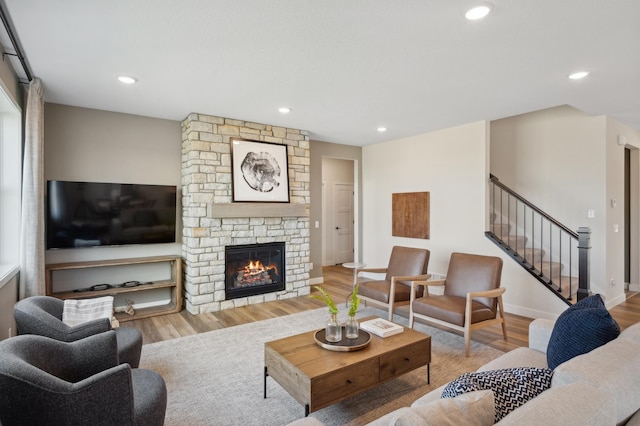 living area featuring wood finished floors, stairs, a fireplace, recessed lighting, and baseboards