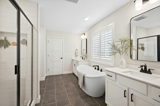 full bath with a shower stall, a freestanding bath, two vanities, and recessed lighting
