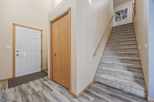 stairs featuring wood finished floors and baseboards