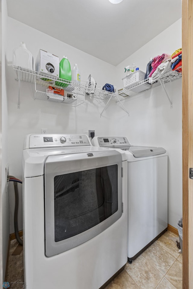 washroom with washer and clothes dryer and baseboards