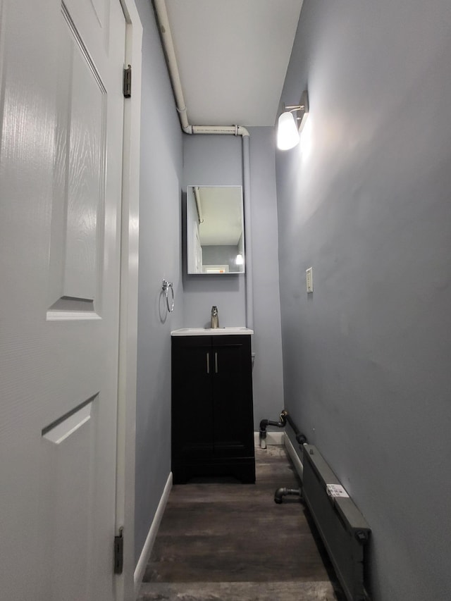 bathroom featuring wood finished floors, vanity, and baseboards