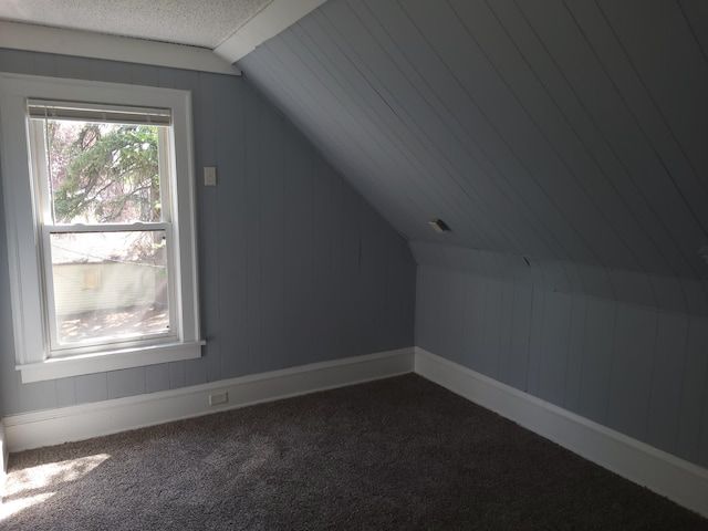 bonus room with vaulted ceiling, carpet, and baseboards