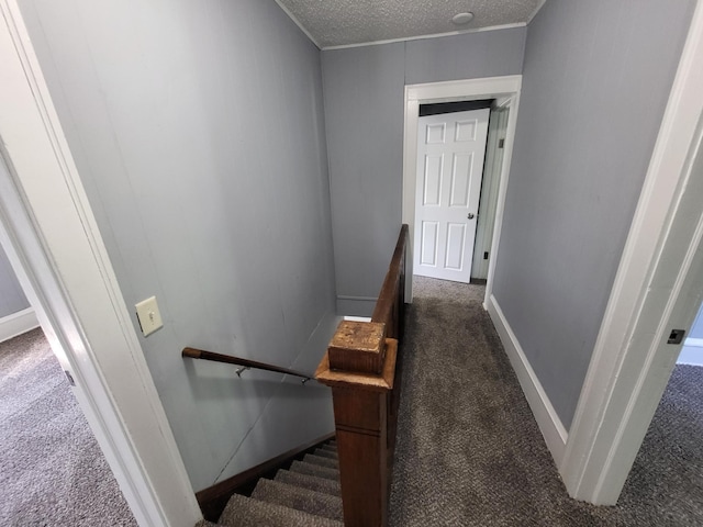 stairs with carpet flooring, a textured ceiling, and baseboards