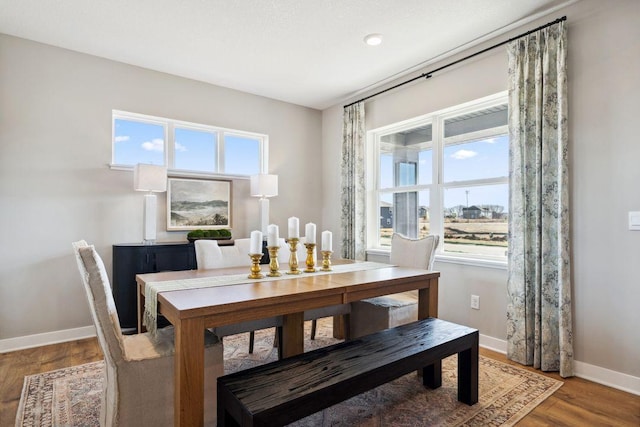 dining space featuring baseboards, wood finished floors, and recessed lighting