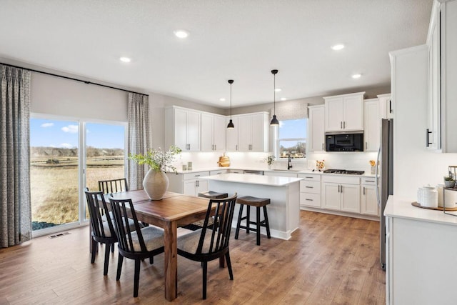 dining room with light wood-type flooring and recessed lighting