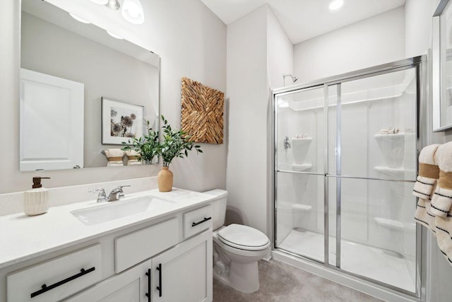 bathroom featuring a shower stall, toilet, and vanity