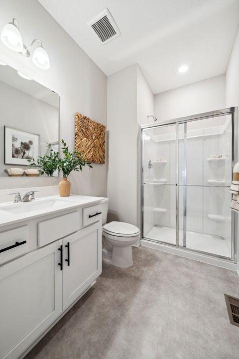 bathroom featuring vanity, a stall shower, and toilet