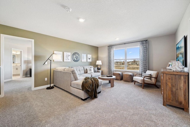 living area featuring light carpet, a textured ceiling, and baseboards
