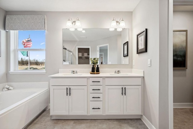 full bathroom with double vanity, a stall shower, a bath, baseboards, and a chandelier