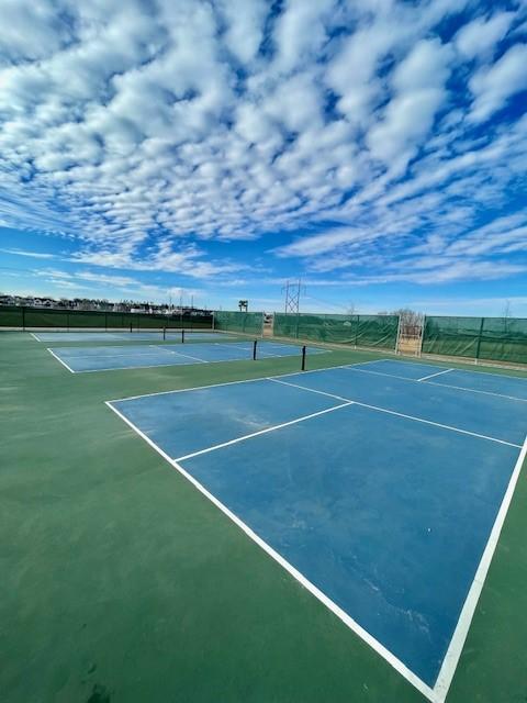 view of tennis court featuring fence