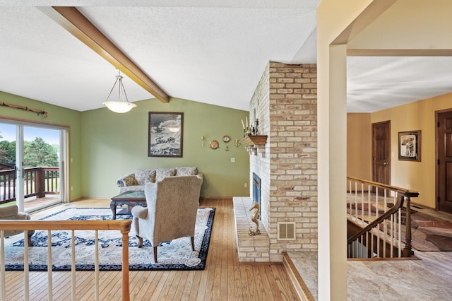 32355 Nottingham Ct, Chisago Lake Twp, MN 55045 - living room featuring hardwood / wood-style flooring, a textured ceiling, and a brick fireplace