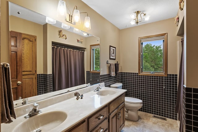 32355 Nottingham Ct, Chisago Lake Twp, MN 55045 - full bathroom with tile walls, toilet, a wainscoted wall, double vanity, and a shower with curtain