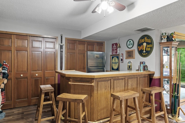32355 Nottingham Ct, Chisago Lake Twp, MN 55045 - indoor dry bar with freestanding refrigerator, a textured ceiling, a ceiling fan, and dark wood-type flooring