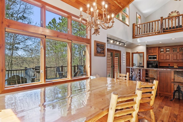 12640 Fawn Lake Rd, Crosslake, MN 56442 - dining area with high vaulted ceiling, light wood-style flooring, and a chandelier