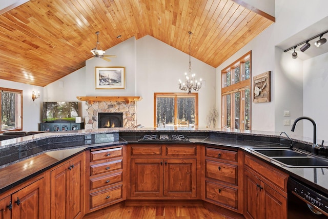 12640 Fawn Lake Rd, Crosslake, MN 56442 - kitchen with a sink, black dishwasher, stainless steel gas stovetop, wood finished floors, and brown cabinets