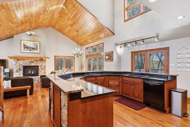 12640 Fawn Lake Rd, Crosslake, MN 56442 - kitchen featuring black dishwasher, a sink, light wood-style flooring, high vaulted ceiling, and healthy amount of natural light