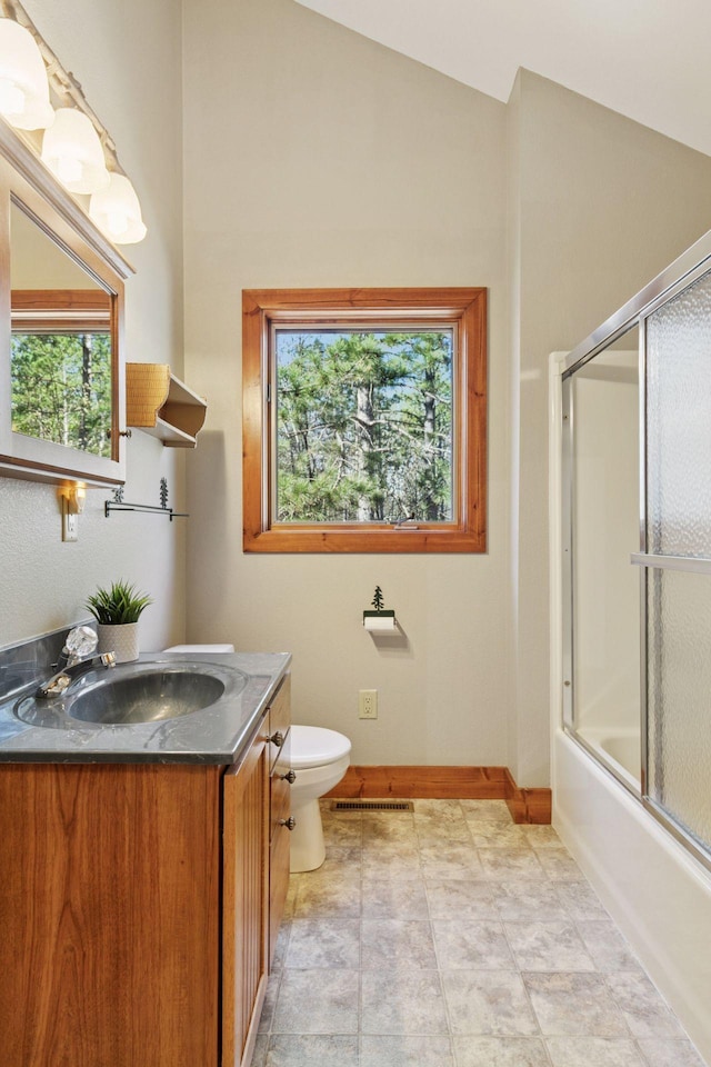 12640 Fawn Lake Rd, Crosslake, MN 56442 - bathroom with plenty of natural light, toilet, baseboards, combined bath / shower with glass door, and vaulted ceiling