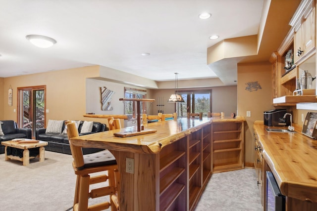 12640 Fawn Lake Rd, Crosslake, MN 56442 - kitchen featuring butcher block countertops, open shelves, a sink, light carpet, and a peninsula