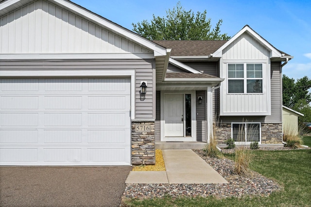view of front of property featuring stone siding, roof with shingles, and an attached garage