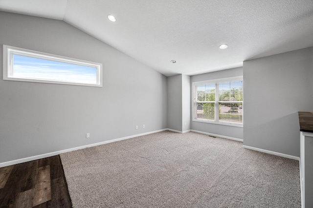 carpeted spare room with vaulted ceiling, baseboards, and recessed lighting