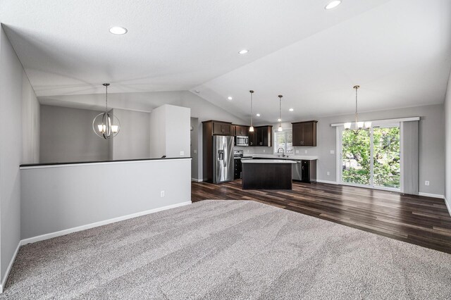 unfurnished living room with dark colored carpet, a chandelier, lofted ceiling, baseboards, and recessed lighting