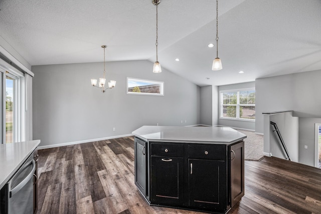 kitchen with dark cabinets, dark wood finished floors, lofted ceiling, a chandelier, and open floor plan