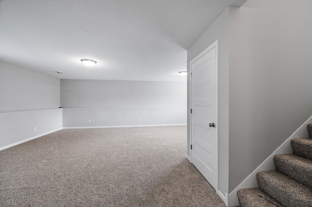 spare room featuring carpet flooring, stairs, and baseboards